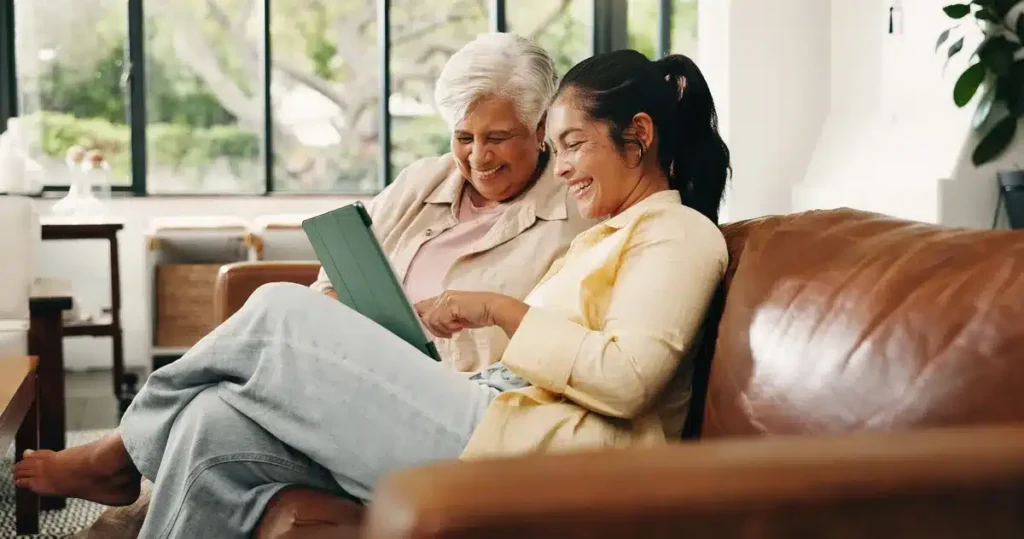 Senior woman and adult daughter looking at table